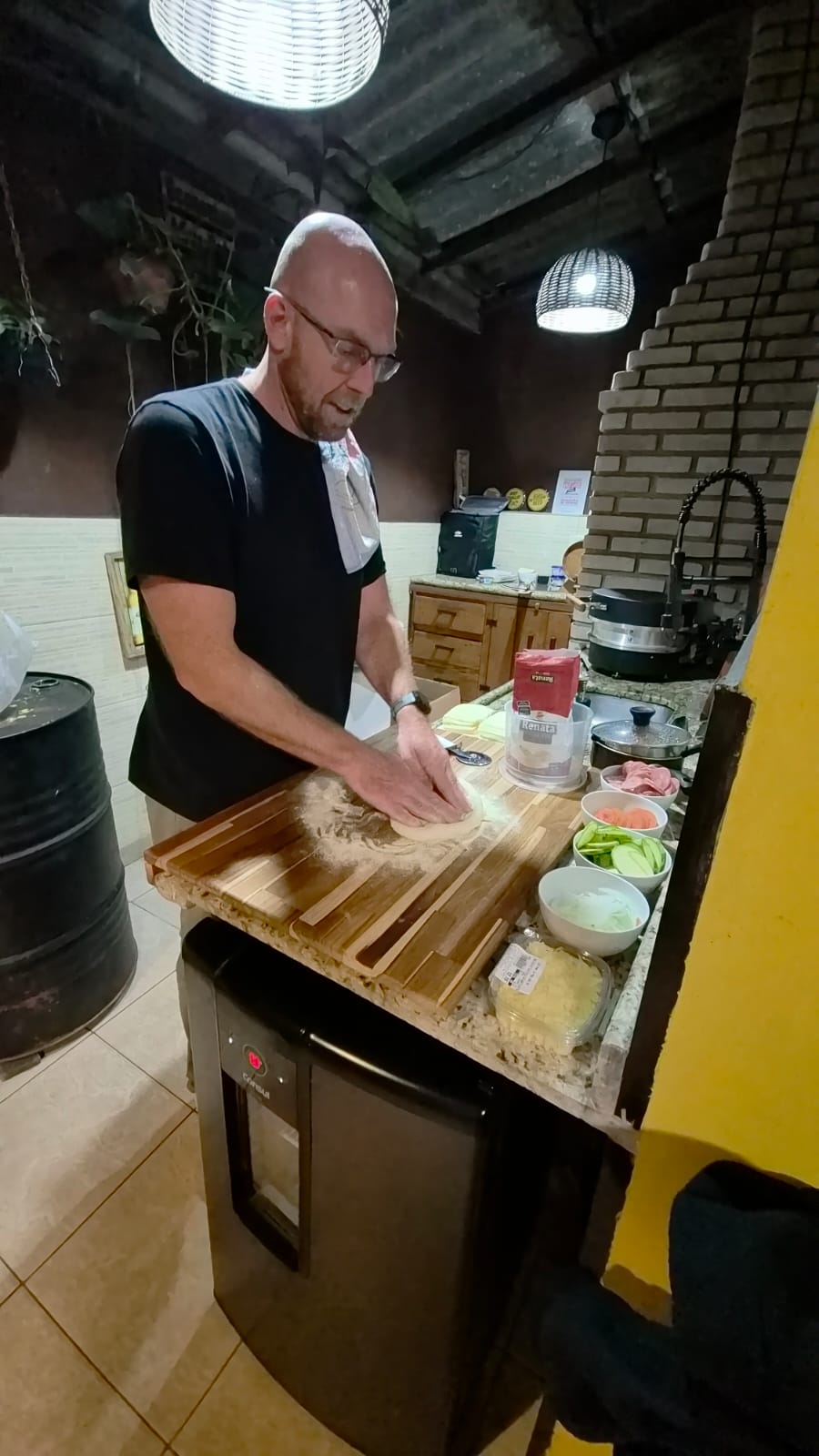 Pizzaiolo abrindo a massa à mão ao lado do forno